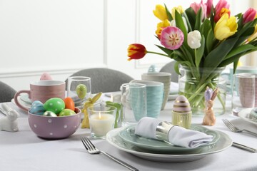 Easter celebration. Festive table setting with beautiful flowers and painted eggs