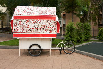 Street sale of fast food. Design of a stall stylized as a cart - bicycle trailer. In the background...