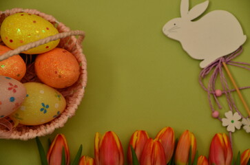Easter, Easter egg color vibrant, spring Orthodox holiday. colorful decorated eggs in a pink basket. happy easter, gift, red yellow tulips. toy white rabbit