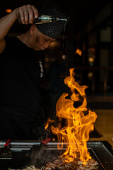 Teppanyaki chef cooking at teppan in a Japanese steakhouse