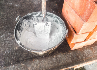 Bucket full white adhesive mortar ready for applicate