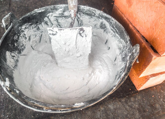 Bucket full white adhesive mortar ready for applicate