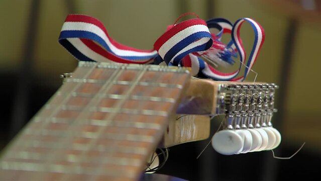 A Typical Chilean String Instrument Called "Chilean Guitarron" with an Attached Ribbon with the Colors of the Paraguayan Flag. Close up.