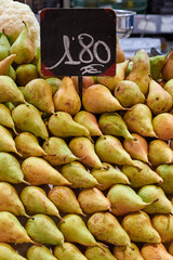 Many pears arranged on a counter in a fruit shop