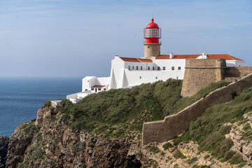 Ein Leuchtturm an der Küste thront auf den Felsen über dem Meer in Portugal an der Algarve bei...