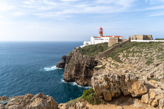 Ein Leuchtturm an der K&uuml;ste thront auf den Felsen &uuml;ber dem Meer in Portugal an der Algarve bei Sagres