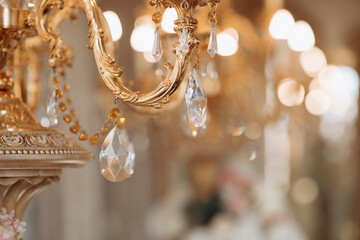 Wedding decoration with antique crystal chandeliers with candles. Glass pendants in the form of balls. Decoration of the wedding ceremony with antique chandeliers. A light bulb in the shape of a candl