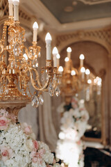 Wedding decoration with antique crystal chandeliers with candles. Glass pendants in the form of...