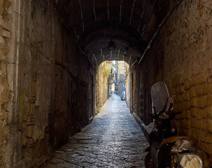 A characteristic Naples alley in the old city, with a scooter parked in the foreground
