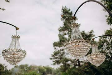 Wedding decoration with antique crystal chandeliers with candles. Glass pendants in the form of...