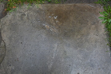Wet concrete asphalt with green grass old after a rainstorm very bright brown background.
