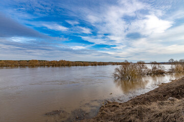 early spring flood, high water in the countryside, river overflowing its banks, trees in the water,...