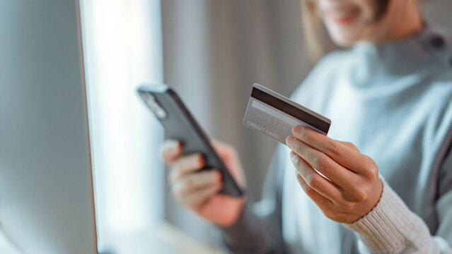 Online payment, Close up - Hands of woman holding a credit card and using smart phone for online shopping