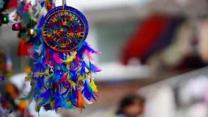 blue dream catcher hanging on shop with blur background