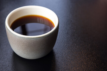 Cup of filter coffee stands on the black table, close-up