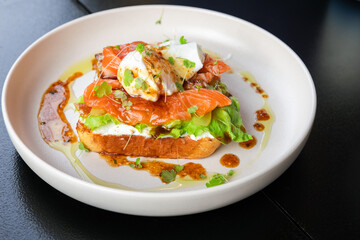 Sandwich with salmon and poached egg, close up photo