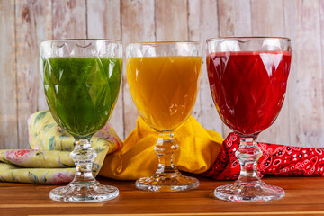 bowls with orange juices, kale with coconut water and apple, and beetroot with orange and carrot
