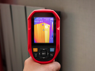 Thermal imaging inspection of heating equipment. Inspection of a heating radiator with an infrared thermal camera close up