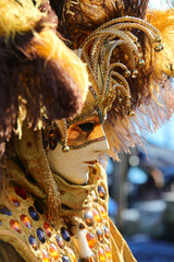 Fototapeta premium Masked Figure in Ornate Costume at Carnival Celebration in Venice in Italy