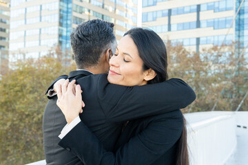 Embracing business colleagues showing support outdoors