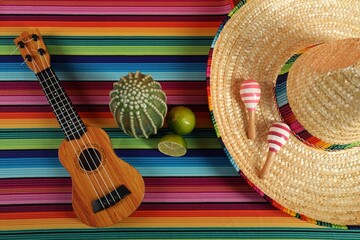 Flat lay composition with Mexican sombrero hat and ukulele on color table