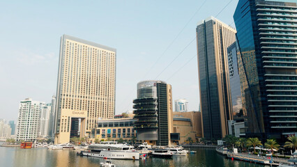 Fototapeta na wymiar A view of the beautiful city of Dubai and the water canal. Action. Sailing boats and sunny embankment.