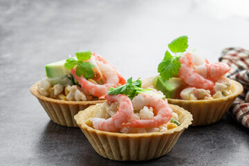 Shrimp and cheese salad tartlets appetizer on gray background