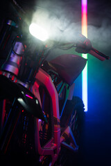 Up close detailed photographs of an electric motorbike taken in a studio with blue, red and orange...