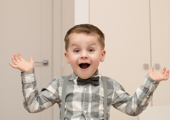 Emotions of surprise and delight on the child's face. A small handsome boy of 4 years old in a...
