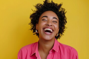 Happy optimistic African American woman in colorful pink clothes laughing isolated on yellow background - obrazy, fototapety, plakaty