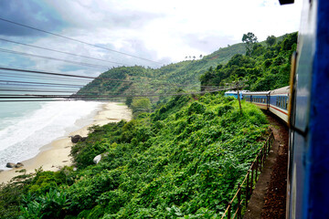 Train running along the coast in the jungle, dramatic landscape