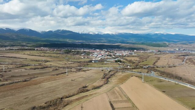 Approaching town Razlog from long distance overviewing rural lands in typical snowless Bulgarian winter.
