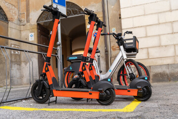 Obraz premium electric scooter and electric bicycle rental subscription service in urban parking in city
