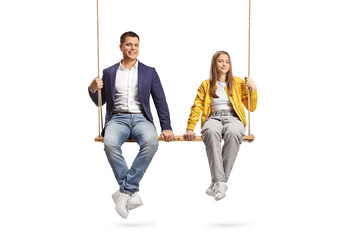 Father and teenage daughter sitting on a big wooden swing