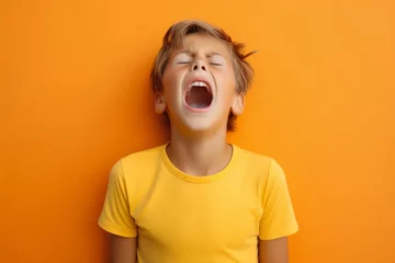 Fotobehang extremely whim Upset blond curly haired boy in t shirt screaming and crying or very emotional expression sings songs with wide opened mouth and closed eyes against orange color wall. Singer audition © useful pictures