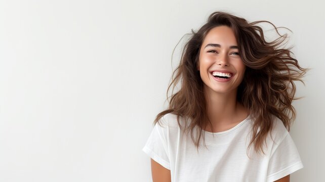A young woman in a white T-shirt, with flowing hair and a bright smile, looks happy and carefree. The modern image is against a white background, giving a fresh feel.
