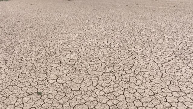 Aerial shot looking down at the cracked surface of a dry lake in Navada