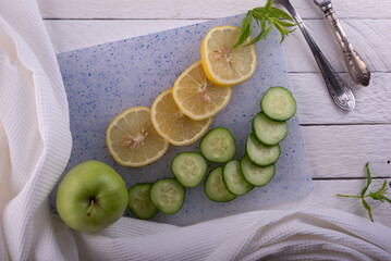 cucumber with lemon still life vegetarian slicing on a white wooden background in a rustic style top view