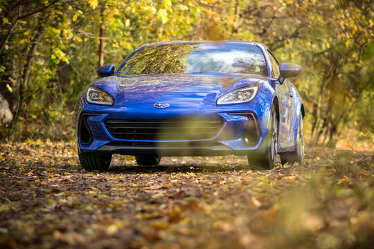 Brno, Czech Republic - October 28, 2023: Fast small sports car Subaru BRZ in the forest. Powerful blue Japanese car outside on a forest road.