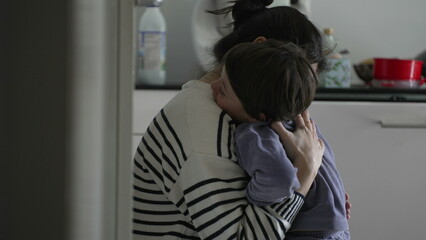 Mother consoling crying hurt little boy, candid tender moment of caring parent giving an empathic...