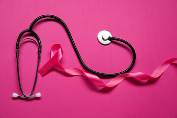 Pink ribbon and stethoscope on color background, flat lay. Breast cancer awareness