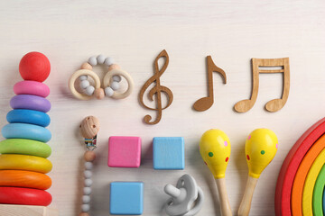Baby song concept. Wooden notes, kids maracas and toys on table, flat lay