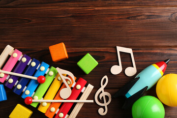 Baby song concept. Wooden notes, xylophone and toys on table, flat lay. Space for text