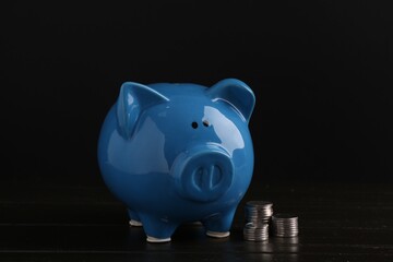 Financial savings. Piggy bank and coins on wooden table