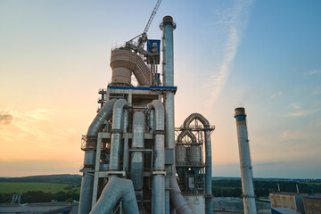 Cement plant with high factory structure and tower cranes at industrial production area....