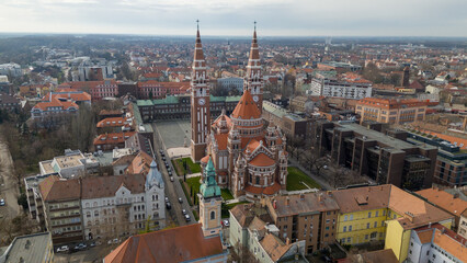 Obraz premium Drone footage from downtown of Szeged, Hungary on a sunny winter day. Szeged, Drone, Aerial, Hungary, Urban Landscape, Szeged Cathedral, Tisza River, Bridge