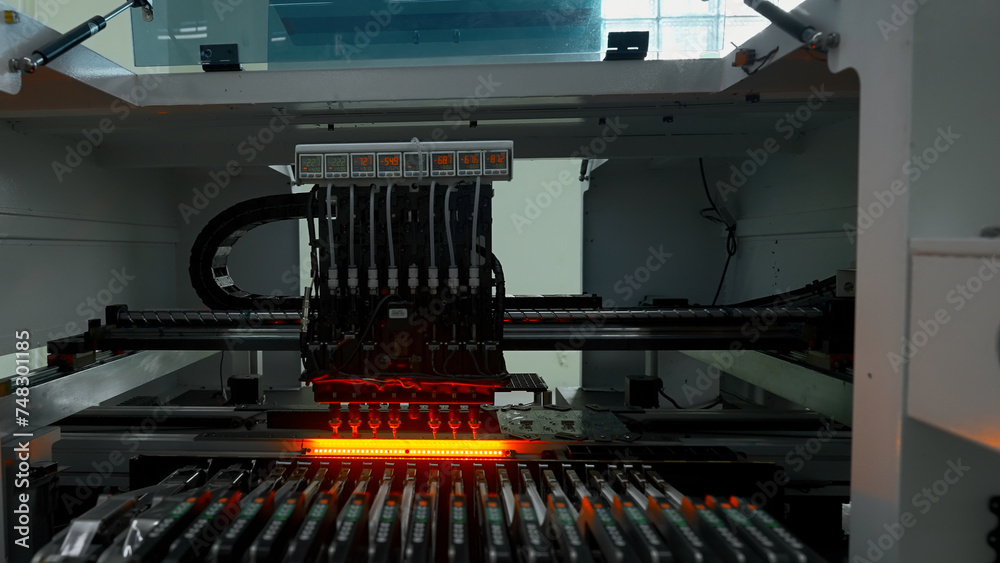 Poster automatic pick and place machine is installing components on circuit board. creative. assembly line 