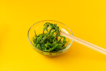 chuka salad in a glass plate with chopsticks