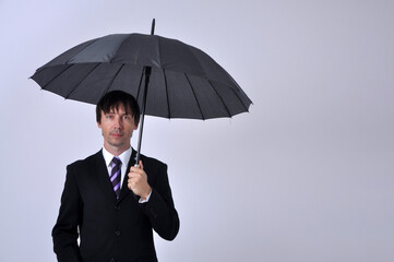 homem de negócios vestido para o comércio  segurando quarda chuva , conceito de turbulencias no mercado 