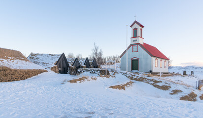 Beautiful old church near Keldur turf house farm, in the south of Iceland during winter. Catholic church in iceland with snowy landscape in the backgroundwith soft afternoon light. Travel destination.